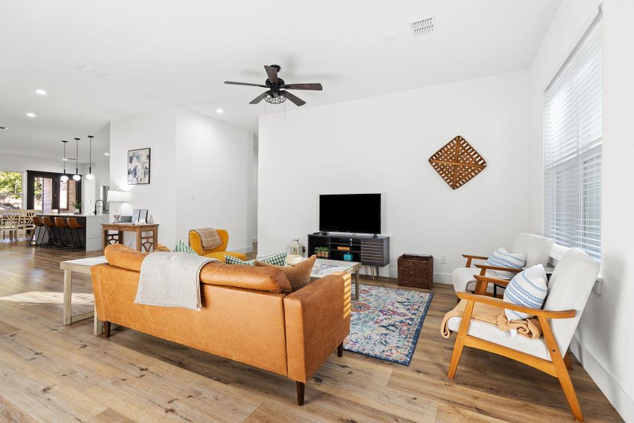 Living room featuring light wood-style flooring, a ceiling fan, and recessed lighting