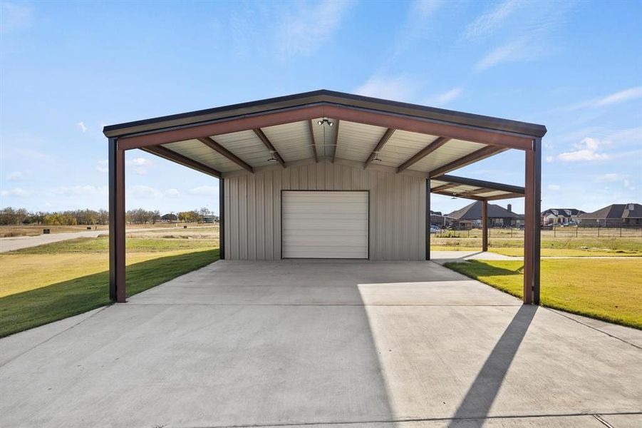 Garage featuring a carport and a yard