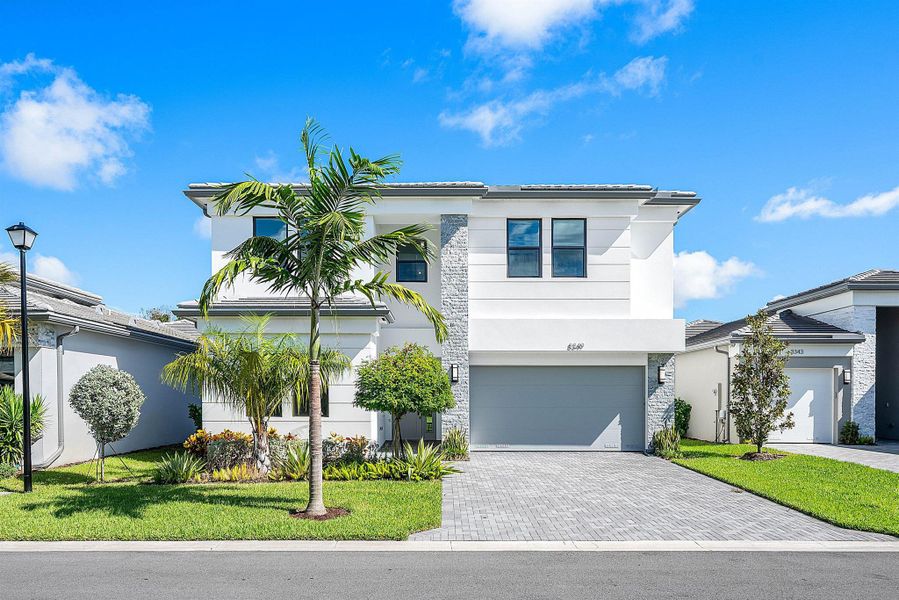 Front exterior of a new home in Lotus Edge, Boca Raton, FL, highlighting curb appeal (Image 1).