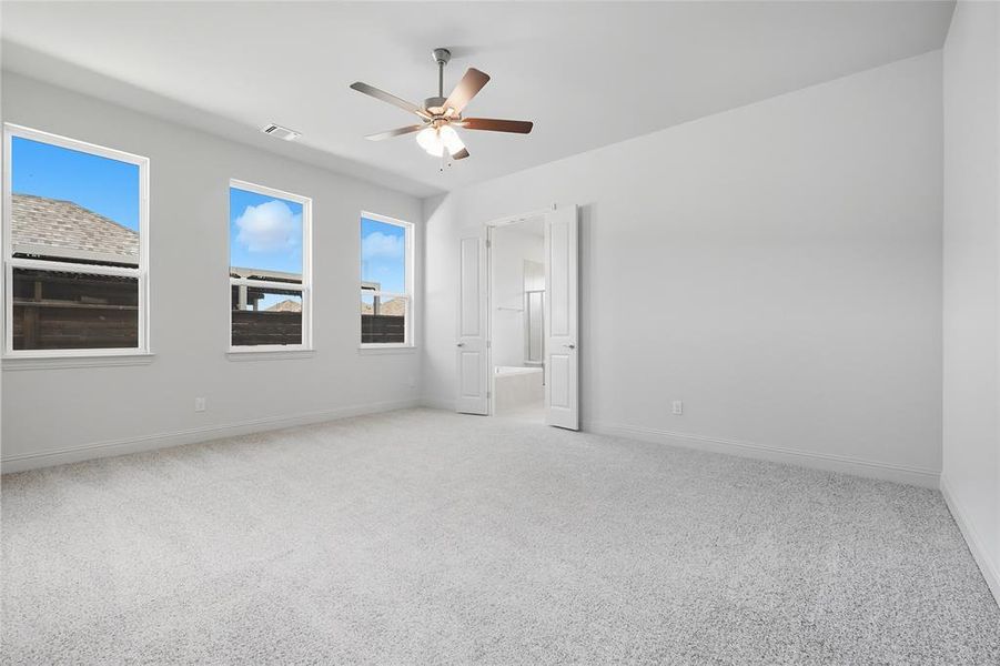 Unfurnished bedroom featuring light carpet and a ceiling fan