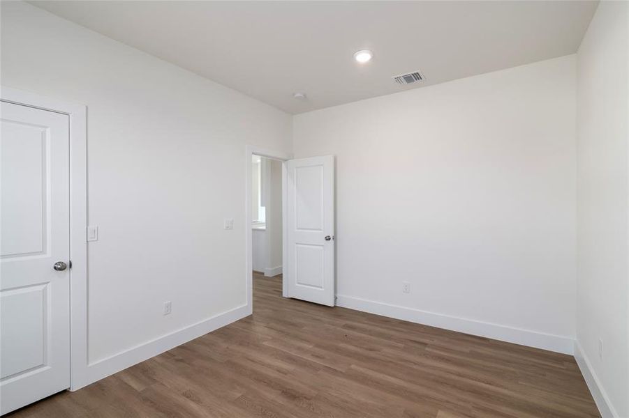 Unfurnished bedroom with hardwood / wood-style flooring