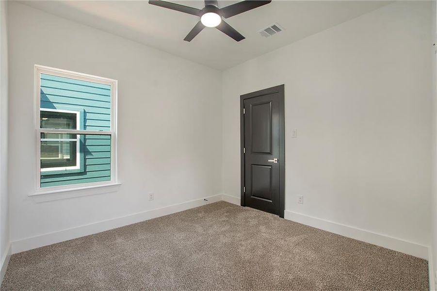 Carpeted empty room featuring ceiling fan