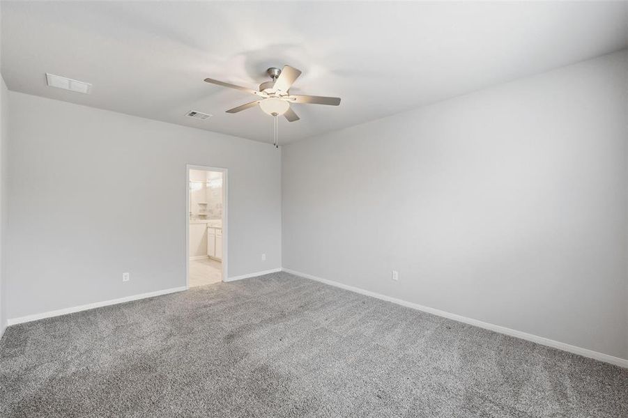 Spare room featuring light colored carpet and a ceiling fan