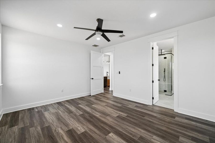 Unfurnished bedroom with dark wood finished floors, recessed lighting, ensuite bathroom, and ceiling fan