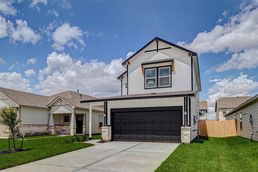 Striking two-story exterior with crisp white siding, bold black trim, stone accents, and a black garage door for a modern farmhouse-inspired look. A wide driveway, fresh front lawn, covered entry, and clean architectural lines create strong curb appeal and a polished first impression.