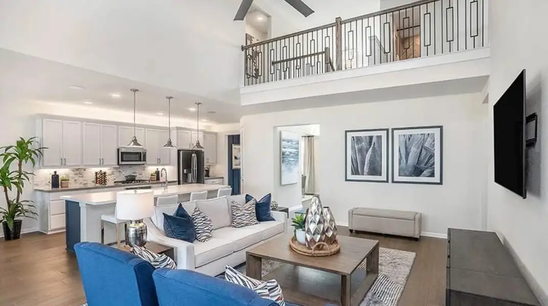 Living area with a towering ceiling, dark wood finished floors, and recessed lighting