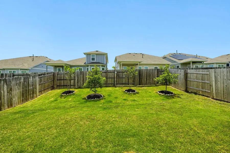 A well-maintained green lawn offers a spacious area for outdoor enjoyment, enclosed by a sturdy wooden fence. A well-maintained green lawn offers a spacious area for outdoor enjoyment, enclosed by a sturdy wooden fence.