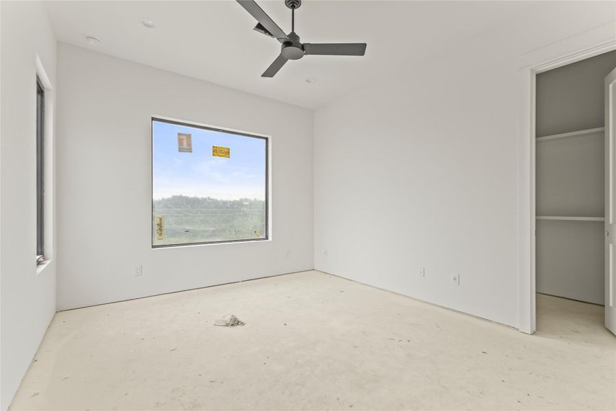 Spacious room with large windows, a ceiling fan, recessed lighting, and an integrated closet with shelving