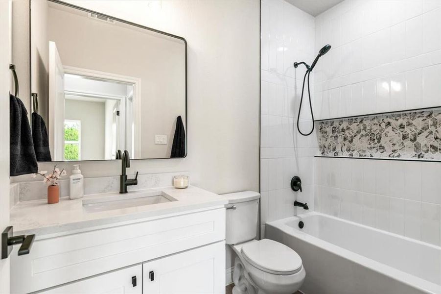 Bathroom featuring a white vanity with integrated sink, white countertop, and matte black fixtures