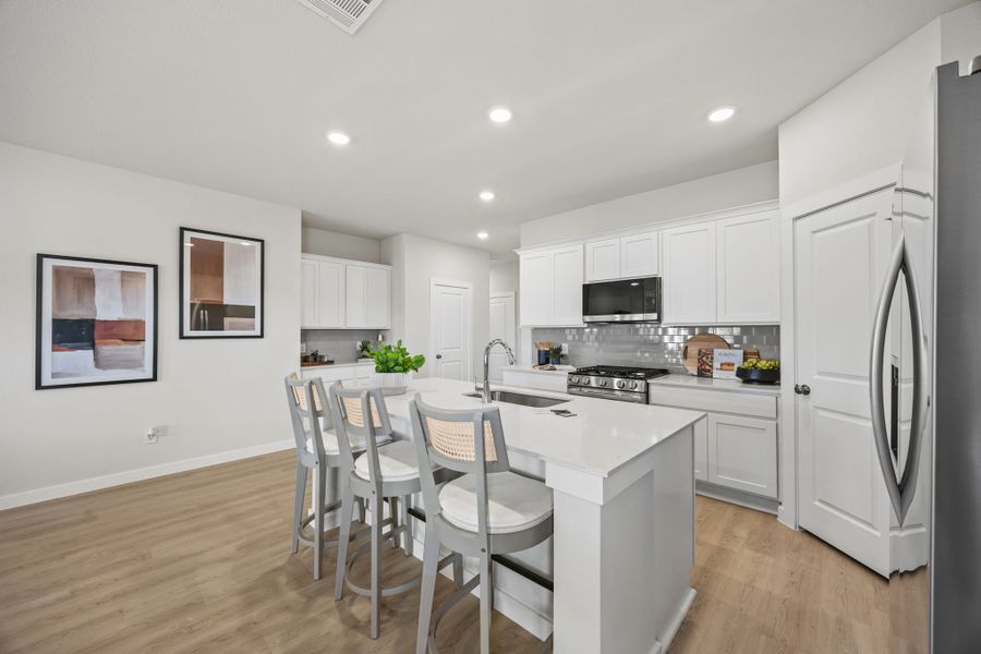 A kitchen with white cabinets.
