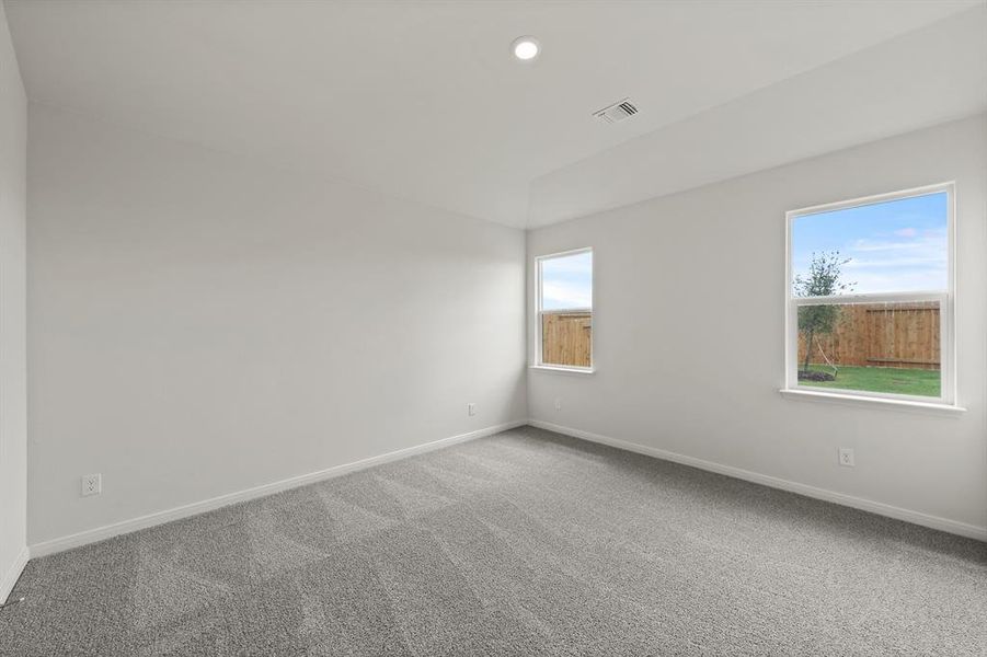 Spare room featuring healthy amount of natural light, carpet, and recessed lighting Spare room featuring healthy amount of natural light, carpet, and recessed lighting