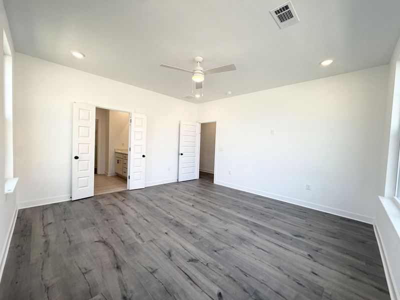 Unfurnished bedroom with ceiling fan, dark wood-style floors, connected bathroom, and recessed lighting