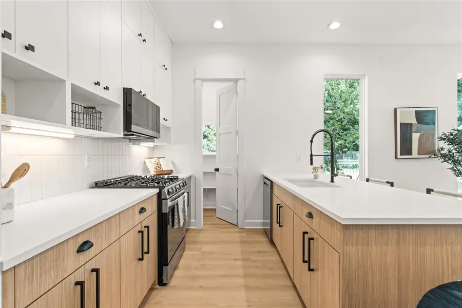 White upper cabinets, warm wood lowers — a kitchen built with contrast in mind, equally with storage maximization. White upper cabinets, warm wood lowers — a kitchen built with contrast in mind, equally with storage maximization.