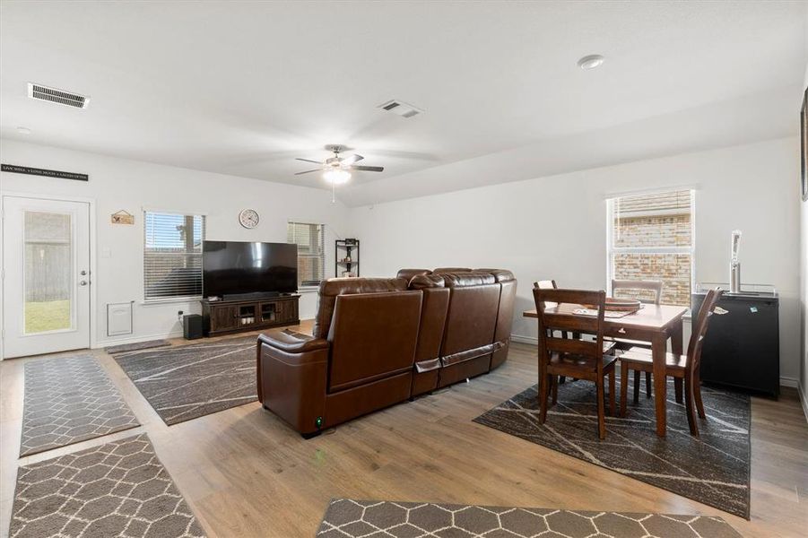 Living room featuring healthy amount of natural light, light wood finished floors, and a ceiling fan
