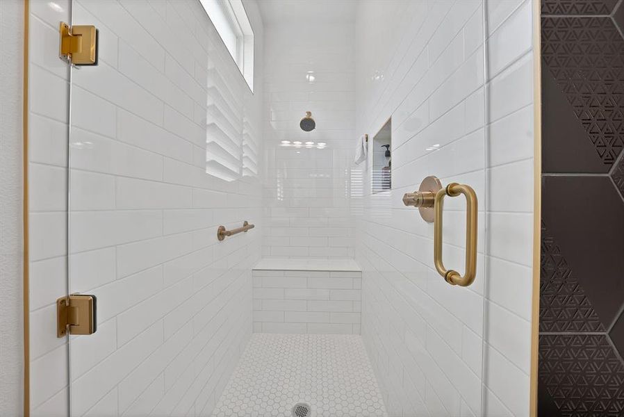 Spacious shower enclosure featuring clear glass panels with gold-tone hardware Spacious shower enclosure featuring clear glass panels with gold-tone hardware