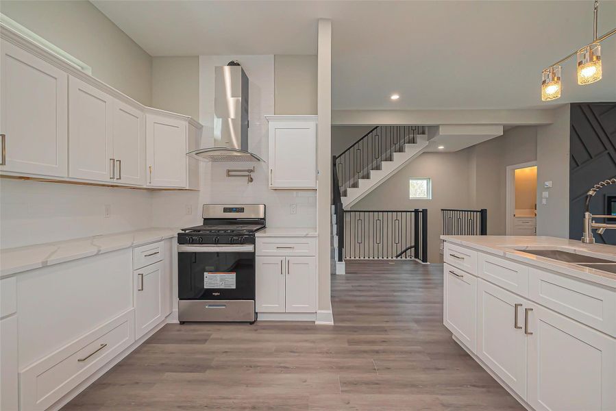 Unit 2: Open kitchen with modern glass and stainless venthood.
