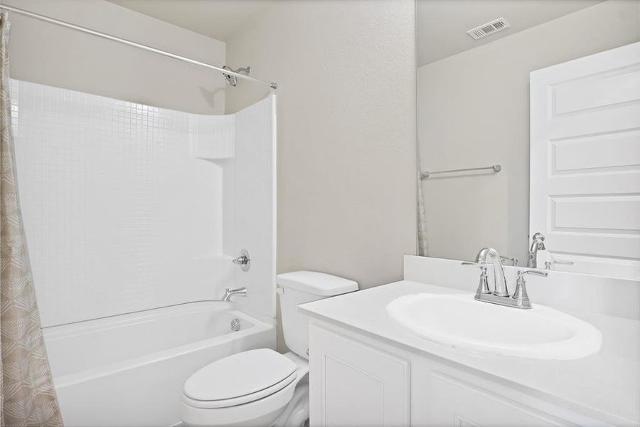 Full bathroom featuring shower / tub combo, vanity, and toilet