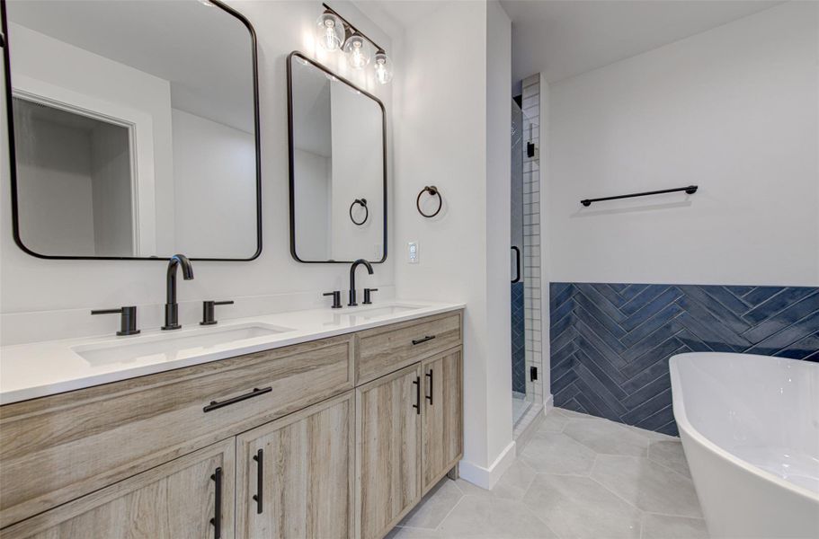 Bathroom with a soaking tub, double vanity, light tile patterned flooring, and a stall shower