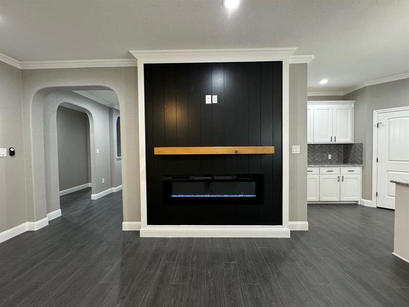 Interior details with backsplash, crown molding, and wood-type flooring