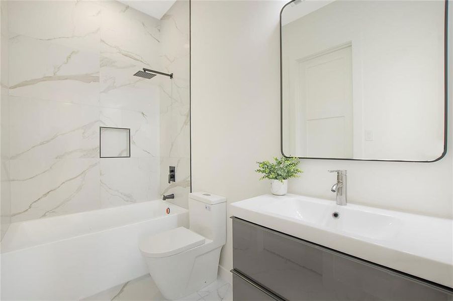 Full bathroom featuring toilet, tiled shower / bath combo, and vanity