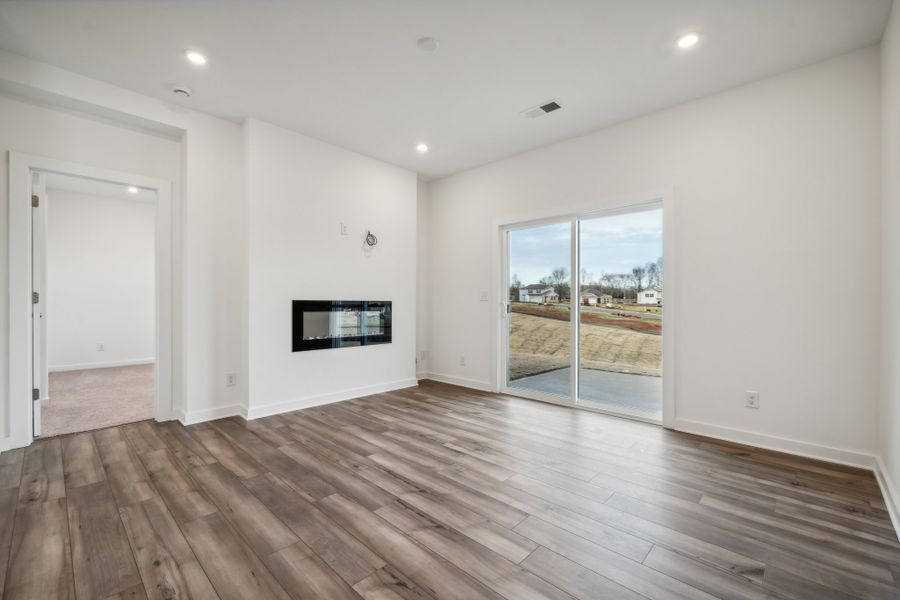 A room with a wood floor and a large window.