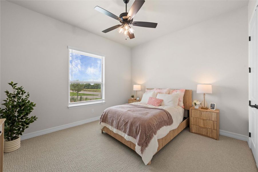 A tranquil bedroom retreat features a window with outside views and a modern ceiling fan. A tranquil bedroom retreat features a window with outside views and a modern ceiling fan.