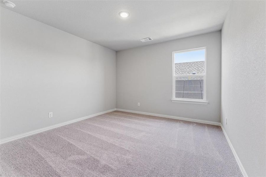 Unfurnished room featuring light carpet and baseboards