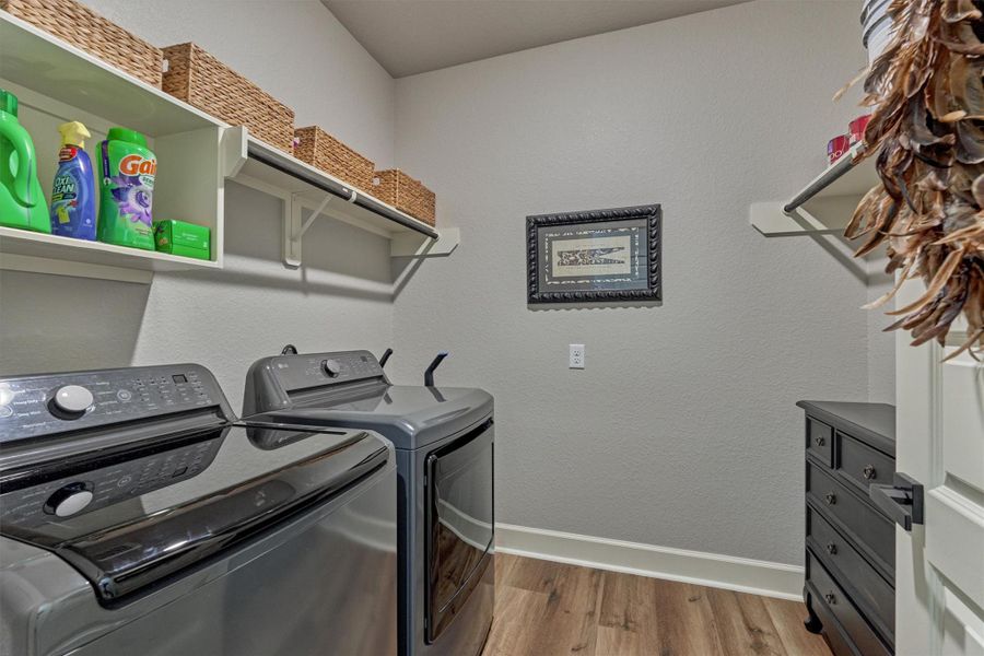 Bright and functional laundry room with generous storage, built-in hanging space, and ample space for folding and organization. Bright and functional laundry room with generous storage, built-in hanging space, and ample space for folding and organization.