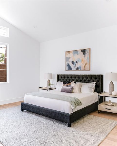 Bedroom featuring lofted ceiling and hardwood / wood-style floors