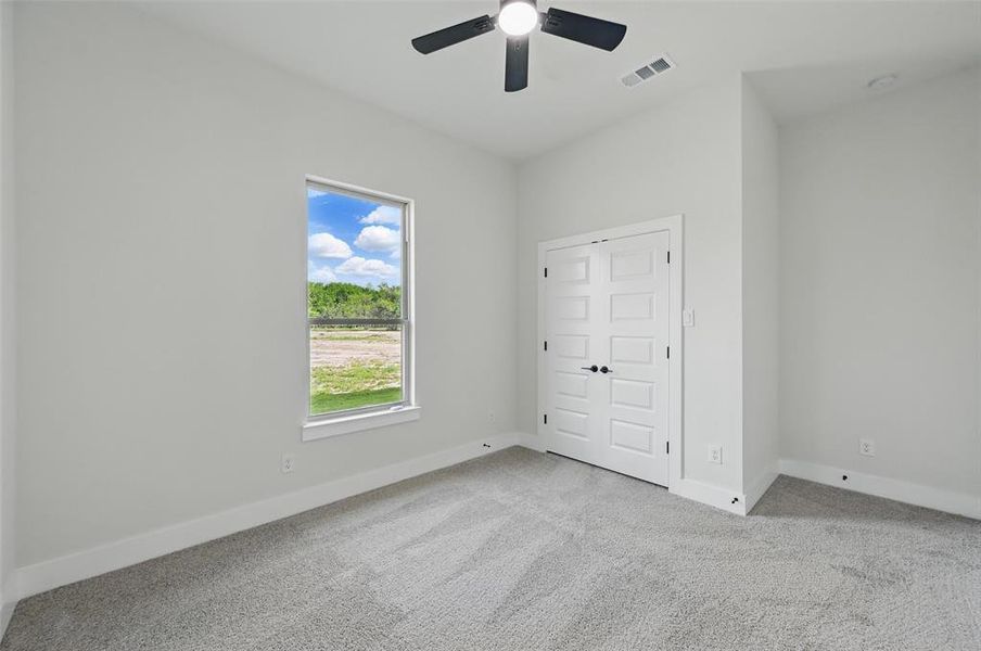 Unfurnished bedroom featuring carpet, baseboards, and a ceiling fan Unfurnished bedroom featuring carpet, baseboards, and a ceiling fan
