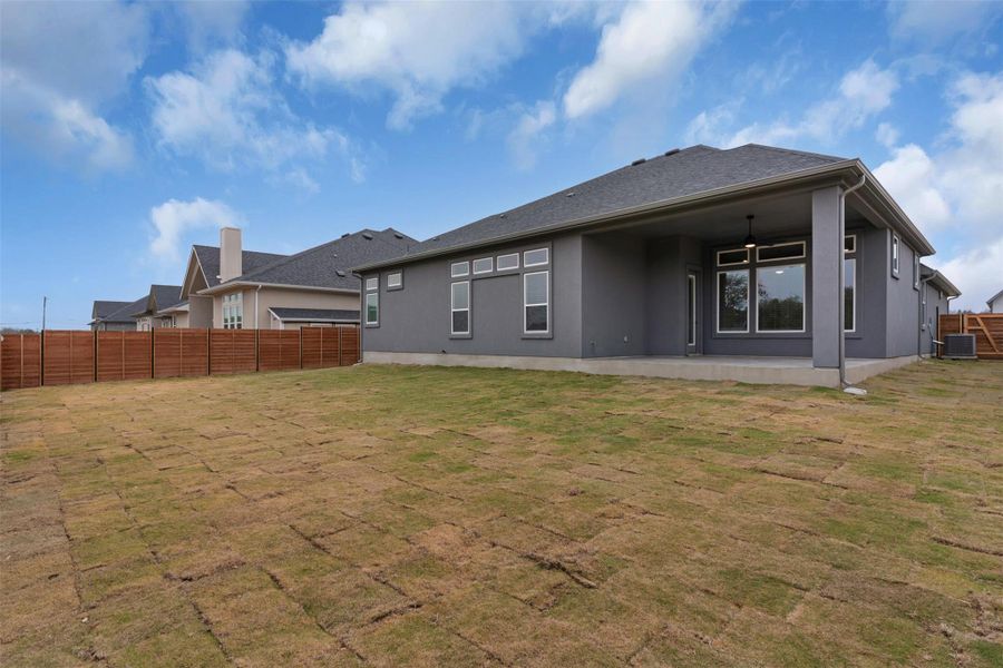 Rear view of property with a fenced backyard, a patio area, and stucco siding