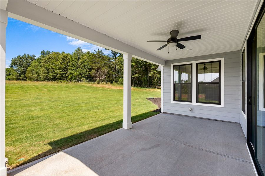 An inviting covered patio opens to a sprawling law