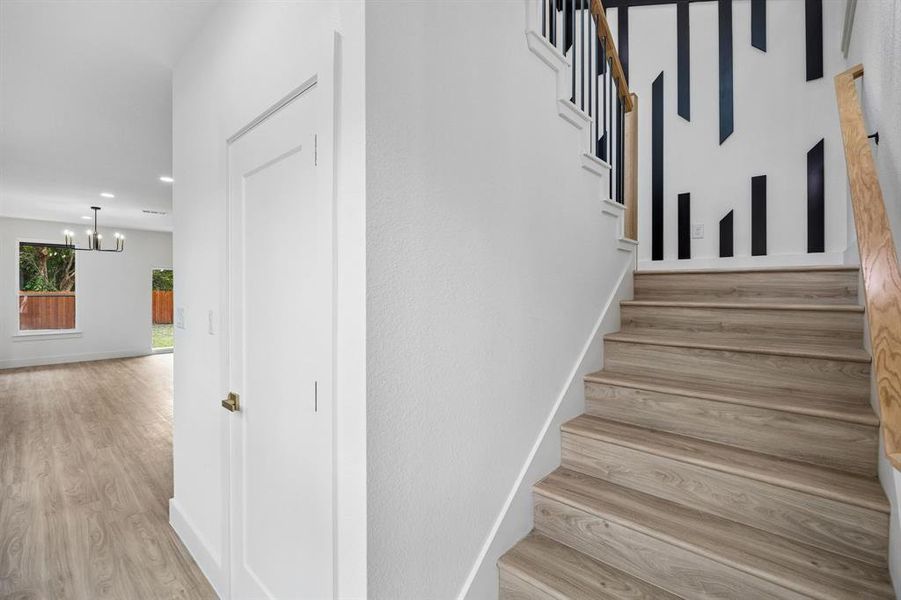 Staircase featuring wood-finish treads, black balusters, and a natural wood handrail Staircase featuring wood-finish treads, black balusters, and a natural wood handrail