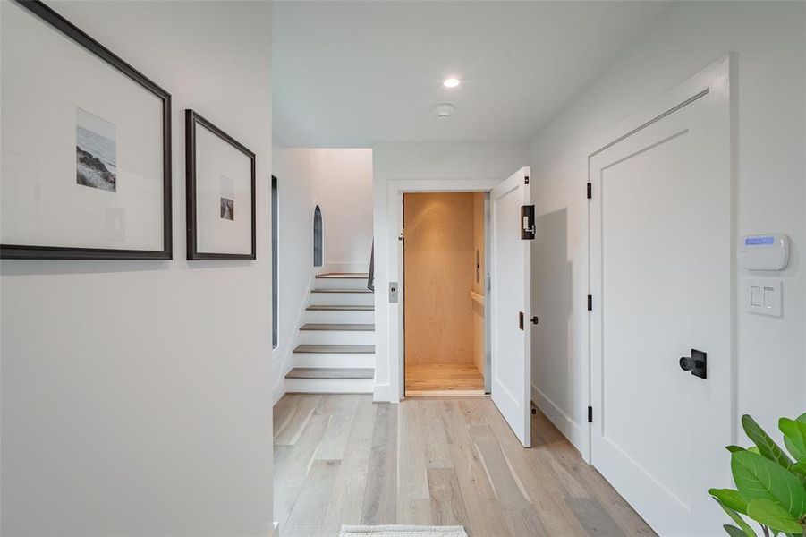 Corridor with light hardwood / wood-style flooring