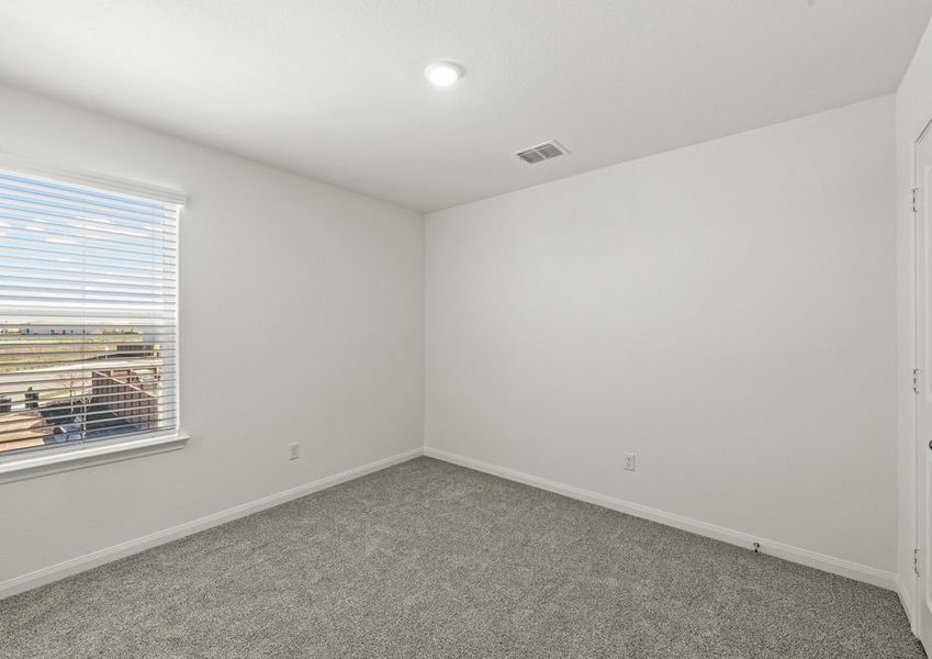 Secondary bedroom with lush carpet flooring