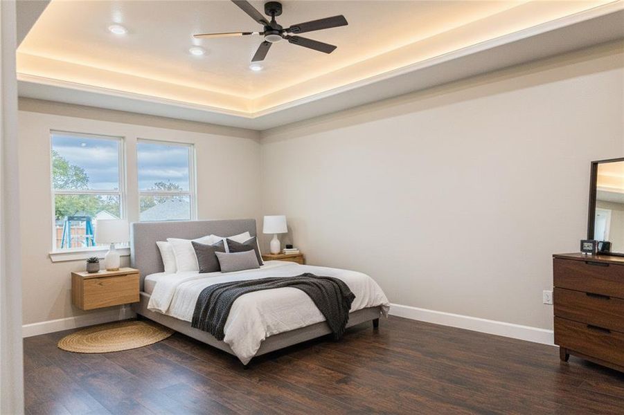 Bedroom featuring dark wood finished floors, a raised ceiling, a ceiling fan, and recessed lighting Bedroom featuring dark wood finished floors, a raised ceiling, a ceiling fan, and recessed lighting