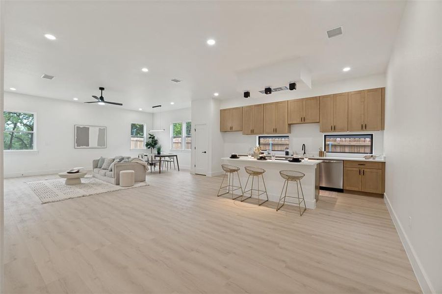 Open-concept living space featuring wood-finish flooring, recessed lighting, and white walls