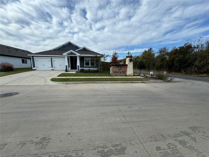 View of front facade featuring a garage and a front lawn