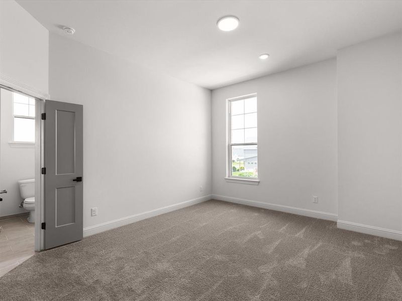 Unfurnished bedroom with light carpet and ensuite bath