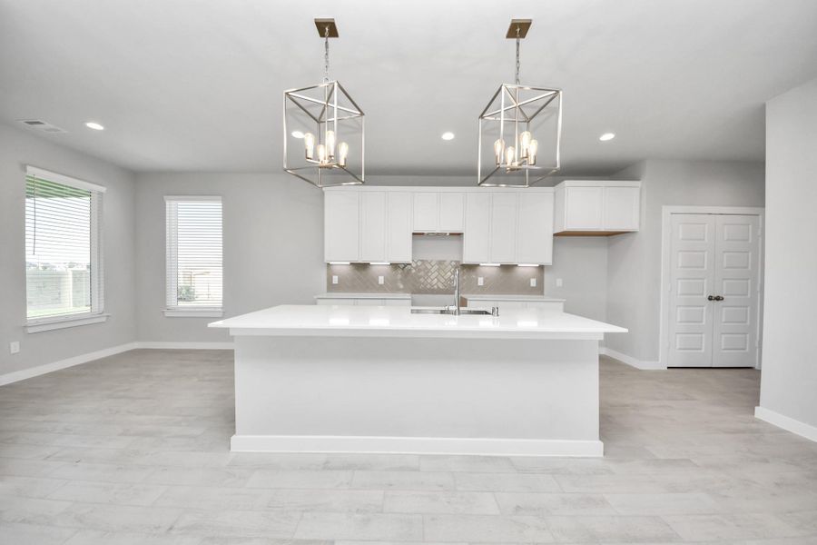 This kitchen is by far any chef’s dream! This spacious kitchen features high ceilings, light stained wood cabinets, granite countertop, SS appliances, modern tile backsplash, recessed lighting, extended counter space, granite kitchen island with double sink, and space for breakfast bar, and a walk-in pantry all overlooking your huge family room. Sample photo of completed home with similar floor plan. Actual colors and selections may vary.