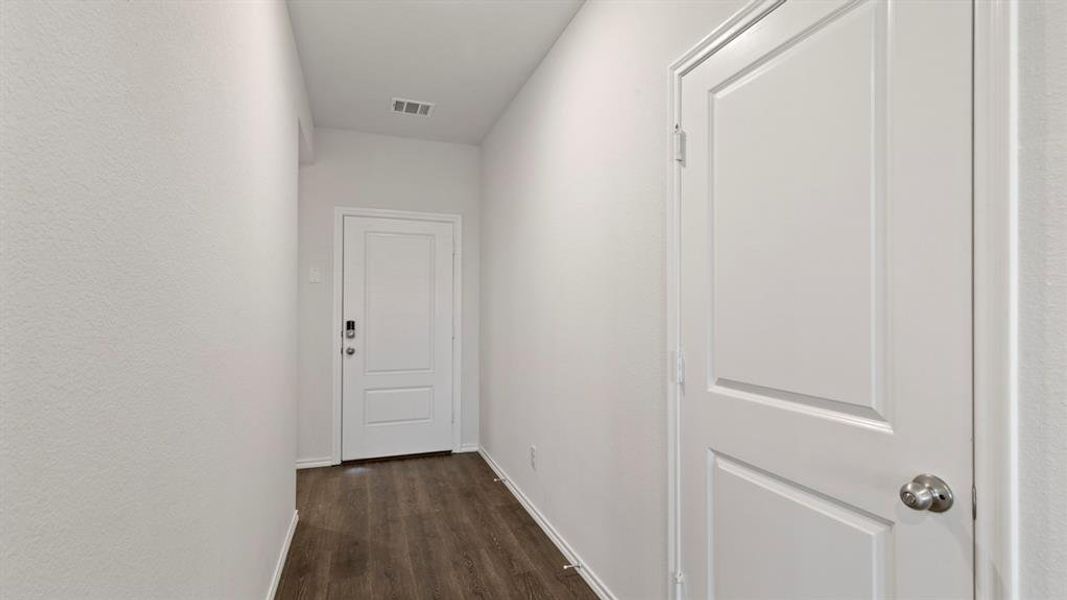 Hallway featuring wood-finish flooring and light-toned walls