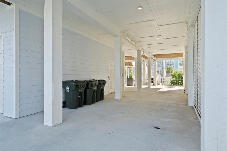 This thoughtfully designed covered area accommodates tandem parking for two vehicles—ideal for compact cars or sedans—while seamlessly integrating organized waste disposal. Clean lines and functional layout reflect the home’s elevated coastal modern aesthetic. This thoughtfully designed covered area accommodates tandem parking for two vehicles—ideal for compact cars or sedans—while seamlessly integrating organized waste disposal. Clean lines and functional layout reflect the home’s elevated coastal modern aesthetic.