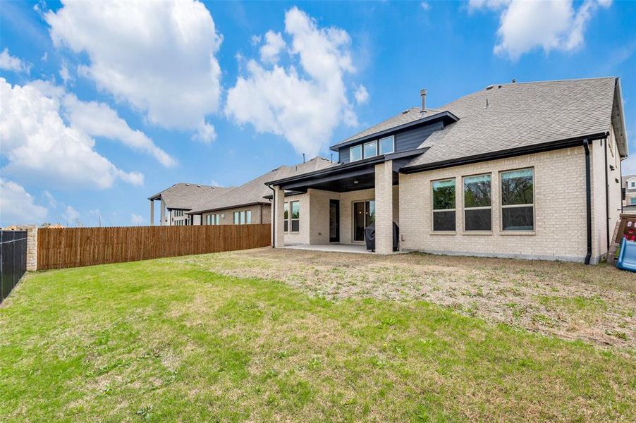 Rear view of property with a patio and a lawn