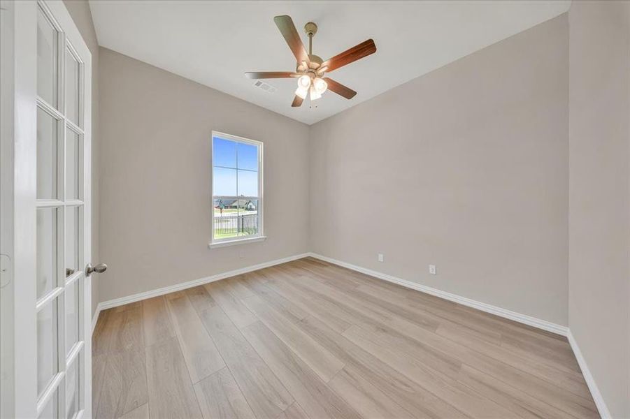 Empty room featuring light wood-style floors and ceiling fan Empty room featuring light wood-style floors and ceiling fan