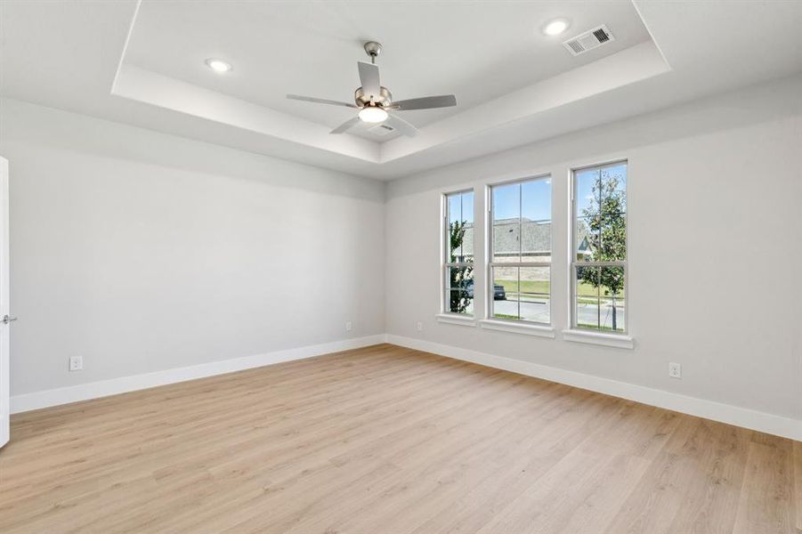 Spare room with a raised ceiling, light wood-style floors, recessed lighting, and ceiling fan Spare room with a raised ceiling, light wood-style floors, recessed lighting, and ceiling fan