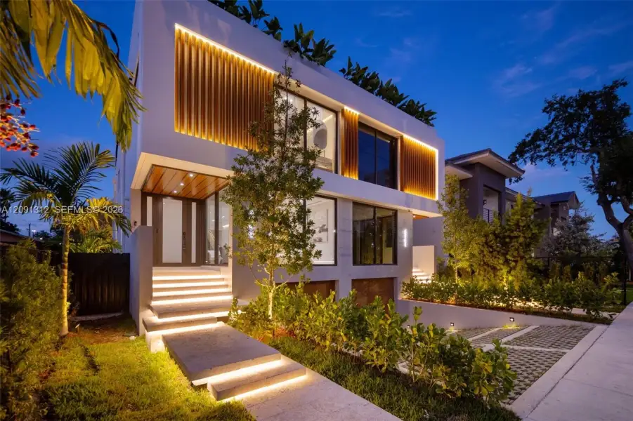 Contemporary multi-story exterior featuring integrated vertical architectural lighting, large-format glass windows, wood-finish paneling, and concrete tiered entry steps Contemporary multi-story exterior featuring integrated vertical architectural lighting, large-format glass windows, wood-finish paneling, and concrete tiered entry steps