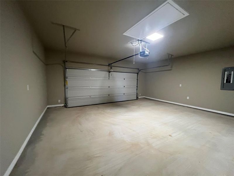 Garage featuring electric panel and a garage door opener