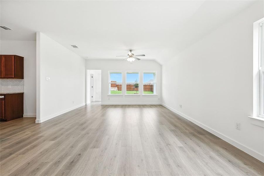Unfurnished living room featuring light wood finished floors and a ceiling fan Unfurnished living room featuring light wood finished floors and a ceiling fan
