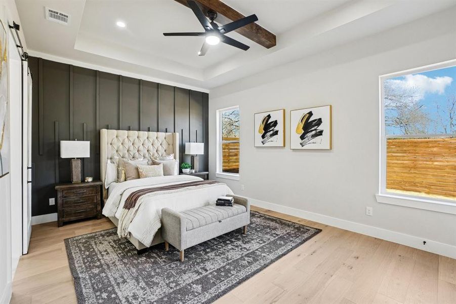 Bedroom with a tray ceiling, light wood-style floors, a ceiling fan, and recessed lighting