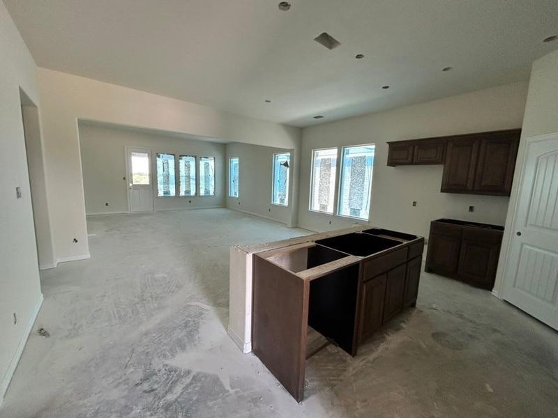 Kitchen featuring plenty of natural light, dark brown cabinets, and a center island